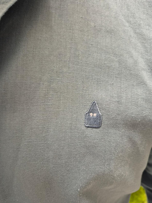 detalle del logo y tejido lino camisa celeste hombre