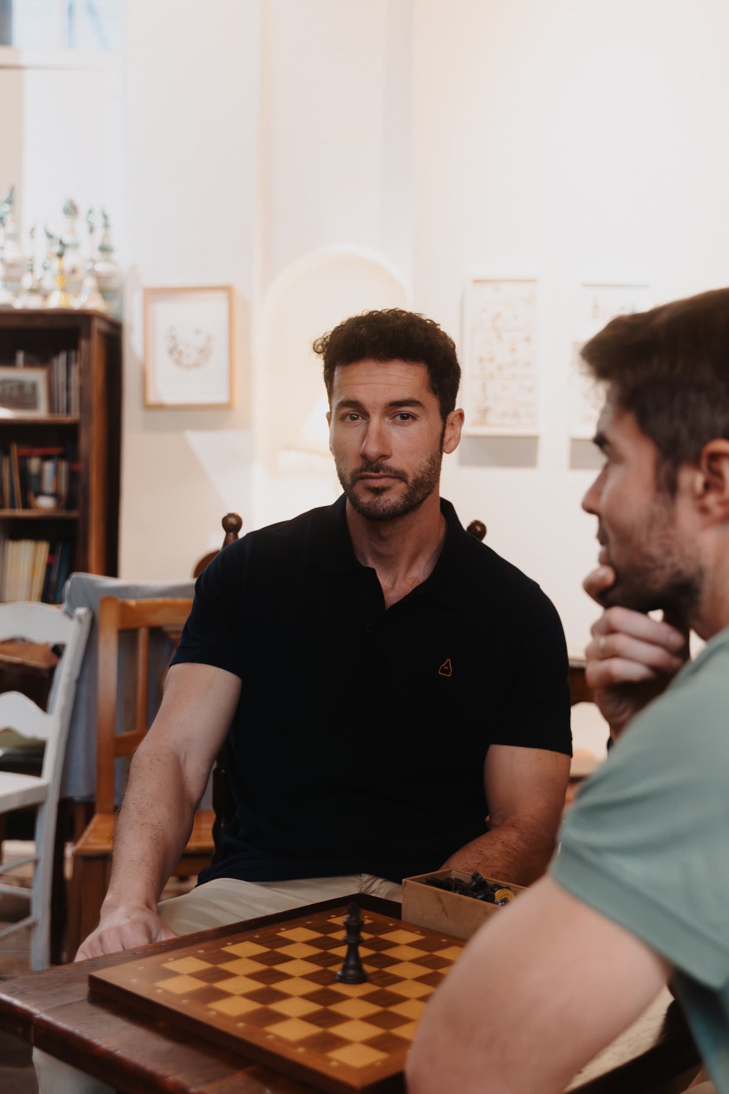 Dos hombres lucen polos azul y verde de vestir.