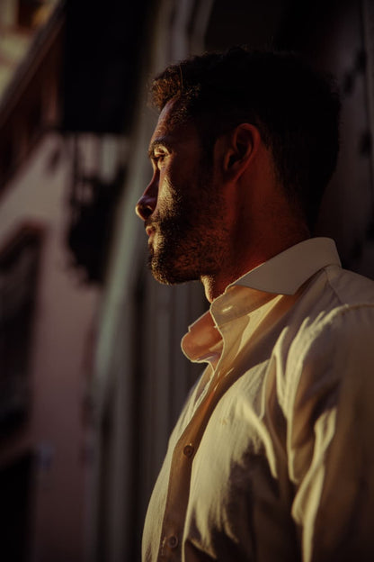 Primer plano de hombre vistiendo camisa crema de algodón TRAMO con cuello italiano en un espacio exterior