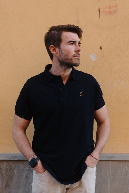 Vista completa del polo azul marino de hombre TRAMO combinado con pantalón beige.
