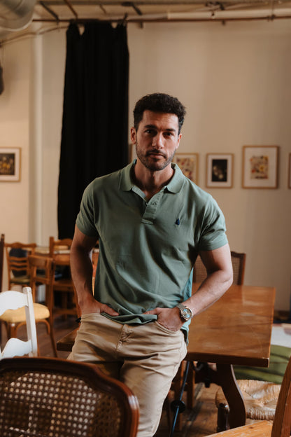 Vista completa de hombre con polo verde TRAMO de algodón combinado con pantalón beige.