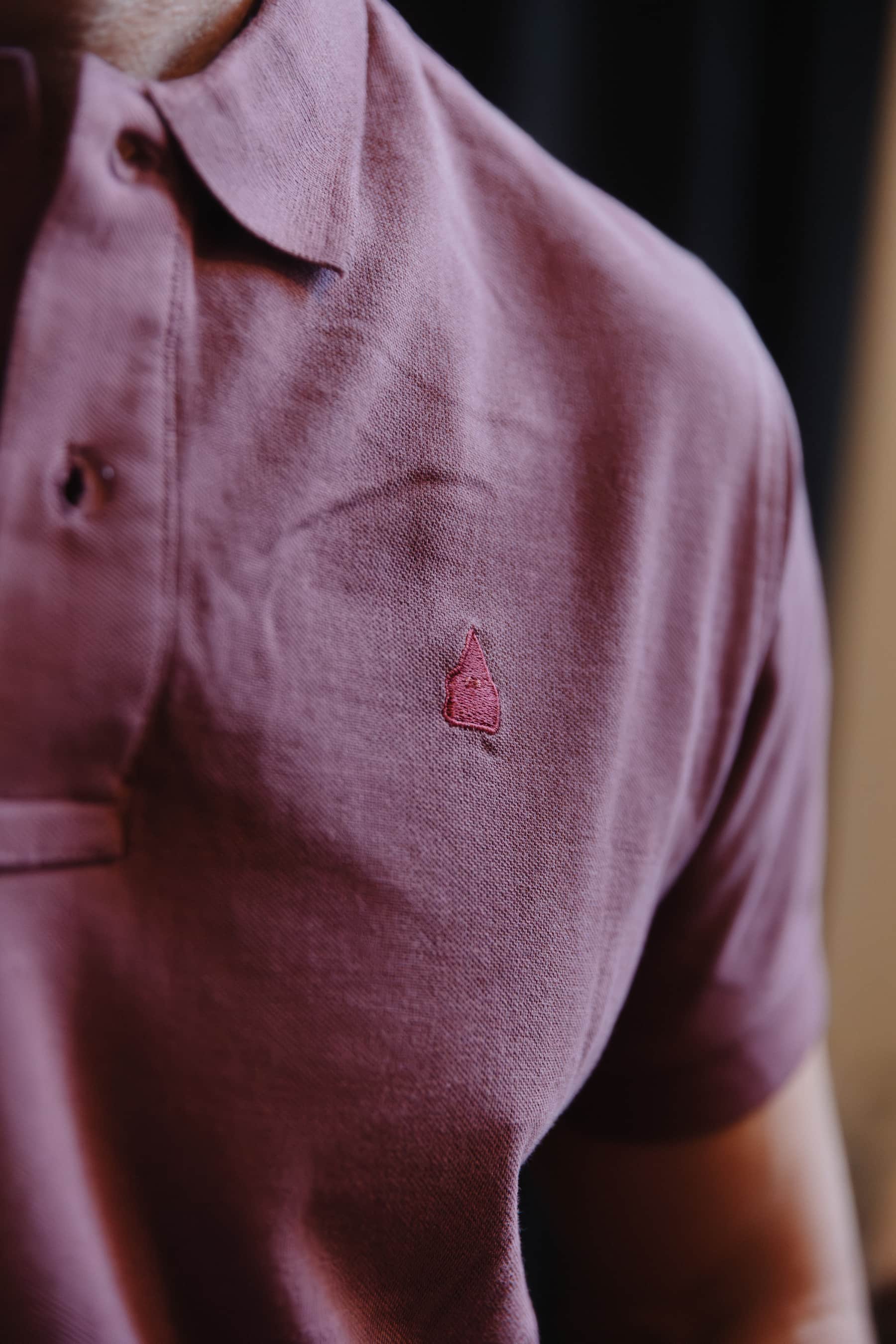 Detalle del nazareno bordado tono sobre tono sobre polo burdeos de algodón TRAMO.